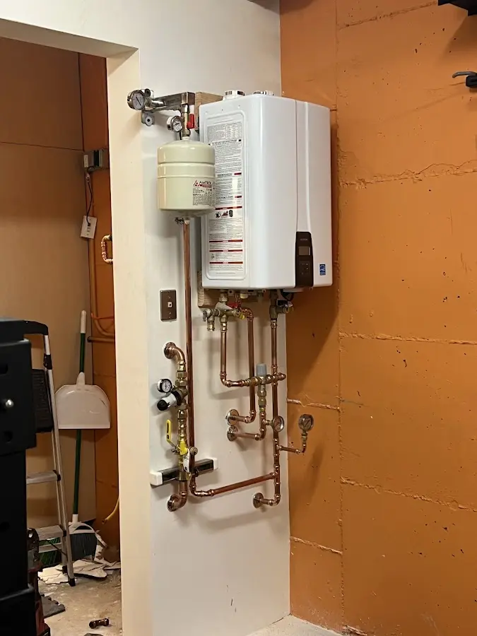 Plumbing technician inspecting water heater connections in Yellow Springs